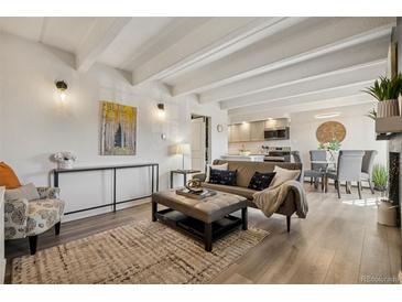 Bright living room with beamed ceilings flows into kitchen and dining room at 655 N Pearl St # 301, Denver, CO 80203