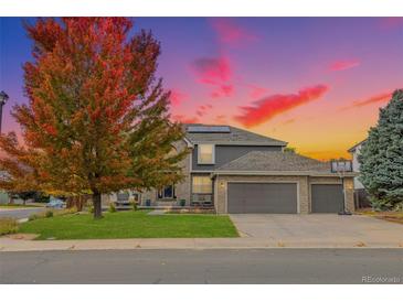 Charming two-story home featuring a three car garage, well-maintained lawn, and beautiful landscaping at 18003 E Alamo Dr, Centennial, CO 80015