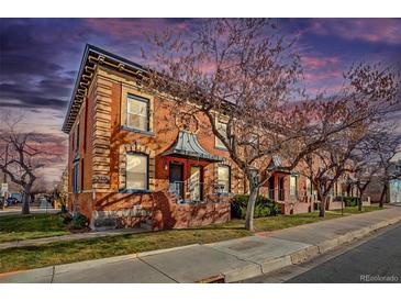 Brick triplex with a charming facade, well-maintained landscaping, and a tree-lined street at 2306 Glenarm Pl # 206, Denver, CO 80205