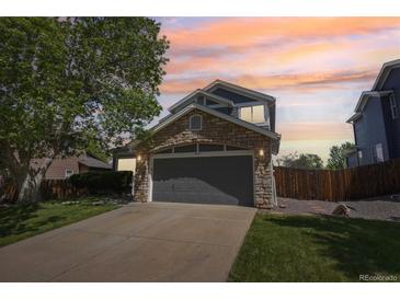 Charming two-story home with a stone-accented facade and well-maintained lawn at sunset at 19157 E Progress Ave, Centennial, CO 80015