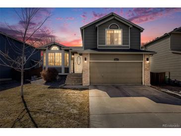 Charming two-story home features a well-maintained lawn, complemented by an attached two-car garage at 9377 Weeping Willow Ct, Highlands Ranch, CO 80130