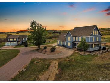 Stunning aerial view of blue house with wrap around porch on large lot at 5537 Lake Gulch Rd, Castle Rock, CO 80104