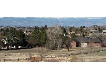 A charming home is surrounded by lush greenery and a picturesque landscape with mountain views in the background at 6503 S Quemoy Way, Aurora, CO 80016