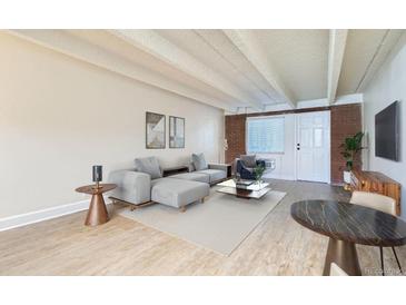 Bright living room features a modern sectional sofa, stylish decor, and ample natural light at 1180 Yosemite St # 110, Denver, CO 80220
