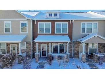 Attractive two-story townhome with stone accents and snowy front yard at 13616 Garfield St # B, Thornton, CO 80602