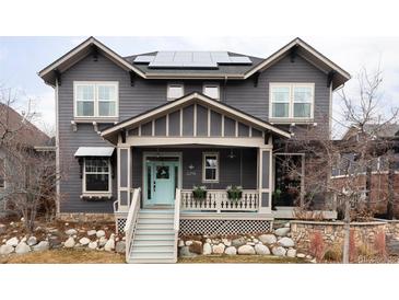 Charming home featuring a covered front porch, blue door, rock garden, and solar panels at 11745 Newton St, Westminster, CO 80031