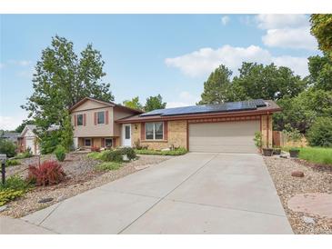 Charming home featuring a well-maintained lawn, solar panels, and a large driveway leading to a two-car garage at 2173 S Ouray St, Aurora, CO 80013