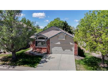 Charming single-Gathering home featuring a brick facade, well-maintained lawn, and an attached two-car garage at 2225 S Lima Ct, Aurora, CO 80014