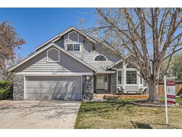 Charming home featuring a gray exterior, stone accents, a well-maintained yard, and a two-car garage at 1737 Jules Ct, Highlands Ranch, CO 80126