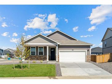 Charming single-story home featuring a well-manicured lawn, stone accents, and an attached two-car garage at 27674 E Byers Ave, Aurora, CO 80018