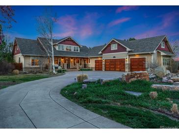 Inviting two-story home featuring a large circular driveway, lush landscaping, and a spacious three-car garage at 14582 Homestead Pl, Broomfield, CO 80023
