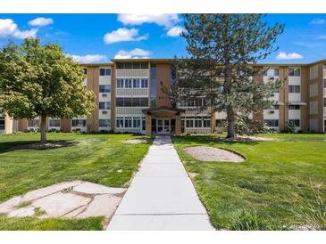 Attractive multi-story apartment building with manicured lawns and mature trees at 9150 E Center Ave # 7C, Denver, CO 80247