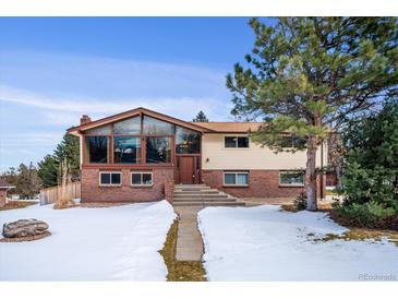 Brick ranch home with large windows and snow-covered yard at 2780 Juniper Dr, Golden, CO 80401