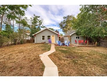 Charming home featuring a spacious backyard with a stone walkway, and an inviting seating area at 3074 S Elati St, Englewood, CO 80110