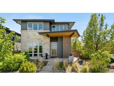 Modern two-story home with stone and brick accents, professionally landscaped front yard at 9154 E 37Th Ave, Denver, CO 80238