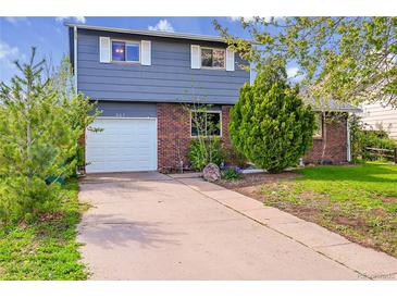 Charming two-story home featuring a brick facade, attached garage and well-maintained front yard at 807 Mobile St, Aurora, CO 80011