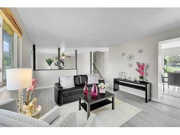 Bright living room with gray floors, modern decor, and comfortable seating arrangement at 807 Mobile St, Aurora, CO 80011