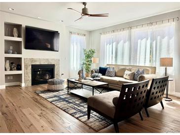 Inviting living room featuring a fireplace, built-in shelves, and ample natural light at 17630 W 94Th Dr, Arvada, CO 80007