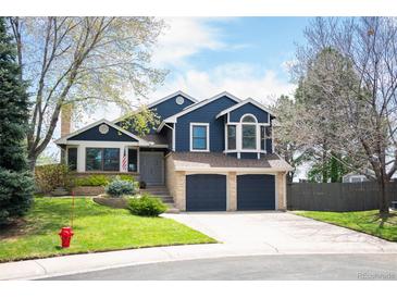 Inviting two-story home with a two-car garage, landscaped yard, and classic architectural details at 18 Brixham Ct, Castle Pines, CO 80108