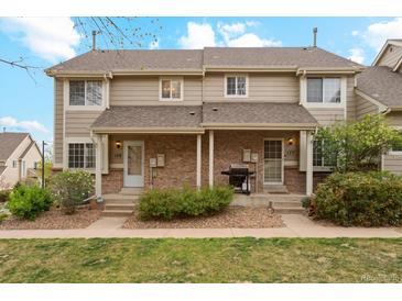 Charming townhome exterior featuring a well-maintained lawn, lush landscaping, and a welcoming front porch at 1470 S Quebec Way # 178, Denver, CO 80231