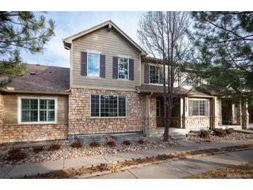 Inviting two-story home featuring a blend of stone and siding, complemented by well-maintained landscaping at 12826 W Brittany Dr, Littleton, CO 80127