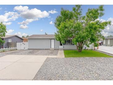 Charming home featuring a well-maintained front yard, healthy tree, and inviting exterior paint at 687 Prairie Ave, Brighton, CO 80603