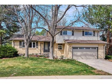 Charming two-story home featuring a brick facade, attached garage, and mature trees enhancing curb appeal at 13183 Spica Dr, Lone Tree, CO 80124