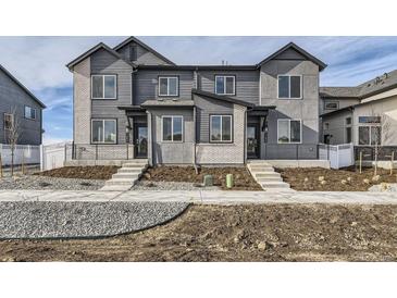 Modern townhouse exterior with gray siding, brick accents, and inviting entryway steps at 1288 S Algonquian St, Aurora, CO 80018