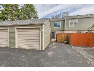 View of the townhome featuring attached garage and partially fenced front patio at 3415 S Ammons St # 24-2, Lakewood, CO 80227