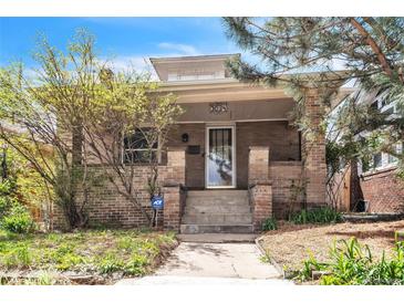 Charming brick home featuring a covered porch, concrete steps and beautiful landscaping at 3024 W Denver Pl, Denver, CO 80211