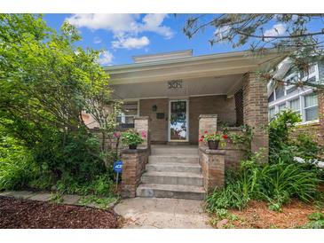 Inviting home featuring a classic brick front porch with lovely landscaping at 3024 W Denver Pl, Denver, CO 80211