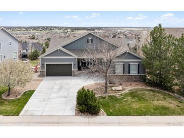 Charming gray home with a well-manicured lawn and a two-car garage in a peaceful neighborhood at 5310 Craftsman Dr, Parker, CO 80134