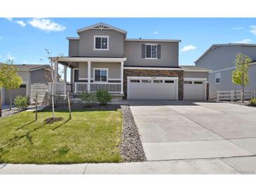Charming two-story home with a well-maintained lawn and a three-car garage at 5166 Trails Edge Ln, Castle Rock, CO 80104