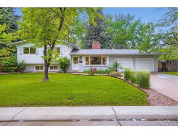 Charming home with a well-maintained lawn, mature trees, and a brick facade at 1715 Alkire St, Golden, CO 80401