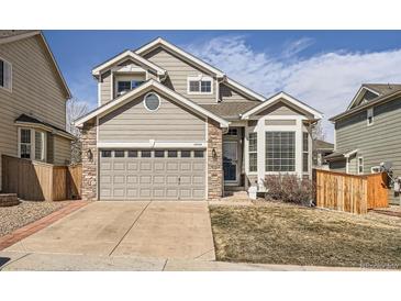 Attractive home exterior with a well-maintained lawn, stone accents, and an attached two-car garage at 16564 High Desert Way, Parker, CO 80134