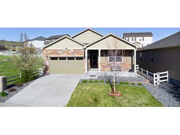 Charming single-story home with a well-manicured lawn and a welcoming covered front porch at 5996 Sun Mesa Cir, Castle Rock, CO 80104