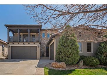 Stunning two-story home with a balcony, three-car garage, stone accents, and professionally landscaped front yard at 2236 S Isabell Ct, Lakewood, CO 80228