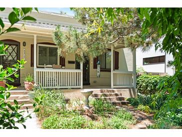 Charming front exterior featuring a cozy porch, mature trees, and professionally landscaped yard at 3319 Newton St, Denver, CO 80211