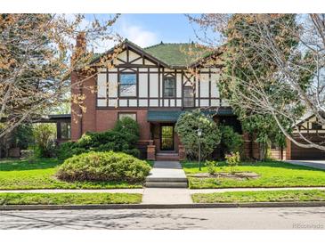 Charming two-story home with a Tudor-style exterior and a well-maintained front yard with landscaped bushes at 1317 Birch St, Denver, CO 80220