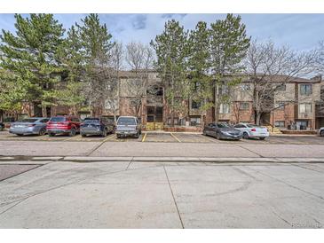 Brick townhome featuring mature trees and an abundance of parking for residents and guests at 324 Wright St # 304, Lakewood, CO 80228