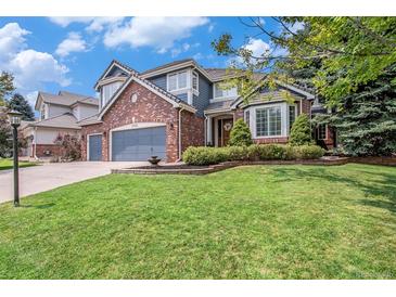 Charming two-story home with a well-maintained lawn, brick accents, and a three car garage at 21416 E Ottawa Cir, Aurora, CO 80016