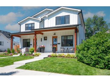 Charming two-story home featuring a welcoming porch with stylish decor and a beautifully landscaped front yard at 2571 S Cherokee St, Denver, CO 80223