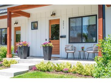 Close-up showcasing the inviting porch with stylish seating, potted flowers, and elegant exterior details at 2571 S Cherokee St, Denver, CO 80223