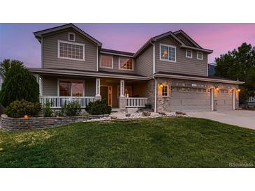 Charming two-story home with a well-manicured lawn, inviting porch, and attached two-car garage at 1805 Parkdale N Cir, Erie, CO 80516