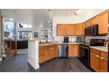 Bright kitchen with stainless steel appliances and wood cabinets at 18242 E Bethany Pl, Aurora, CO 80013