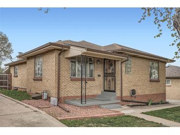 Charming single-story brick home with an inviting entryway and well-maintained landscaping on a sunny day at 4840 Depew St, Denver, CO 80212