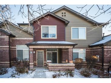 Brick townhouse exterior with a covered entryway and landscaping at 6436 Silver Mesa Dr # E, Highlands Ranch, CO 80130
