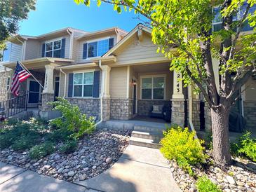 Charming townhome with stone accents, a cozy front porch, and a beautifully landscaped walkway at 12743 W Bowles Pl, Littleton, CO 80127