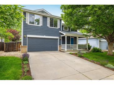 Charming two-story home featuring a well-manicured lawn, inviting front porch, and an attached two-car garage at 1672 Maccullen Dr, Erie, CO 80516
