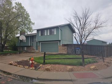 Two-story home with attached garage, basketball hoop, and fenced yard at 880 Orion Dr, Lafayette, CO 80026